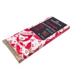 Angled view of Valrhona Guanaja 70% dark chocolate bar in illustrated pink cocoa-themed wrapper.