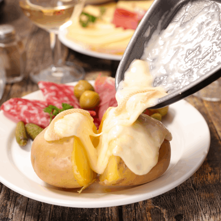 Melted raclette cheese poured over potatoes close-up