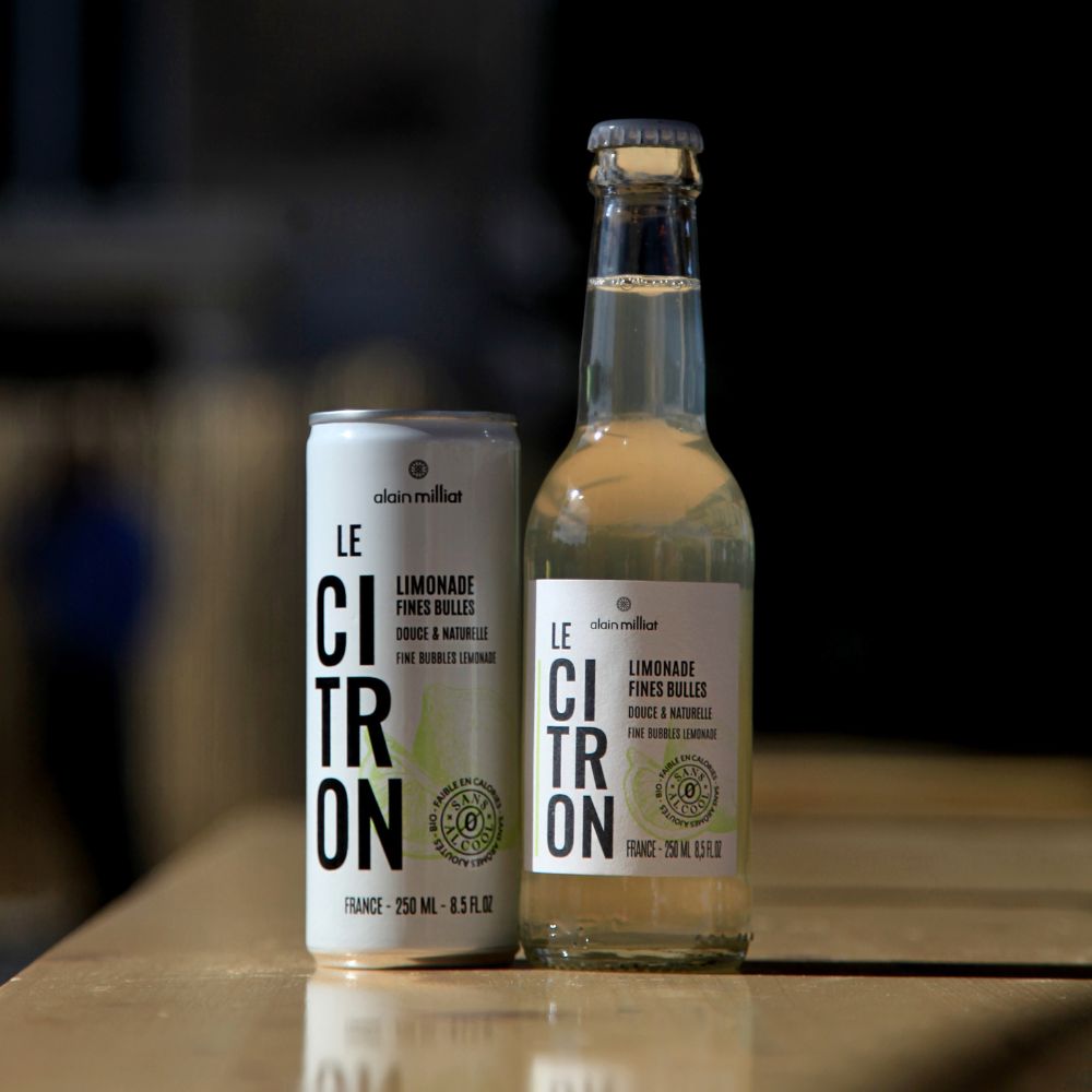 Alain Milliat fine bubbles lemonade 250ml bottle and can displayed together in a lifestyle setting