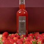 Alain Milliat Sengana strawberry nectar 330ml bottle displayed with fresh strawberries in a lifestyle setting