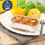 Serving suggestion showing an open 120 g tin of octopus with preserved lemon on a plate with lemons, basil, and a fork.