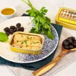 Ferrigno Wild Salmon in Olive Oil shown in an open tin with parsley and prunes